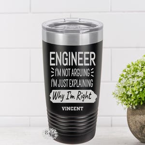 May include: Black stainless steel tumbler with a white inscription that reads "Engineer I'm not arguing I'm just explaining why I'm right Vincent".
