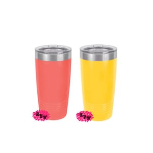 Puede incluir: Dos vasos de acero inoxidable con tapas. Uno es rosa coral y el otro es amarillo.