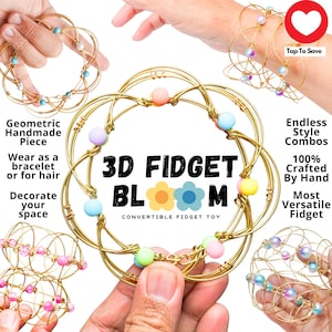 Op de afbeelding: Een gouden 3D-fidget-speelgoed genaamd "3D Fidget Bloom" met kleurrijke kralen. Het speelgoed kan als armband worden gedragen of als bureauspeelgoed worden gebruikt. Het wordt beschreven als "Geometrisch handgemaakt stuk", "Eindeloze stijlcombinaties", "100% handgemaakt" en "Meest veelzijdige fidget".