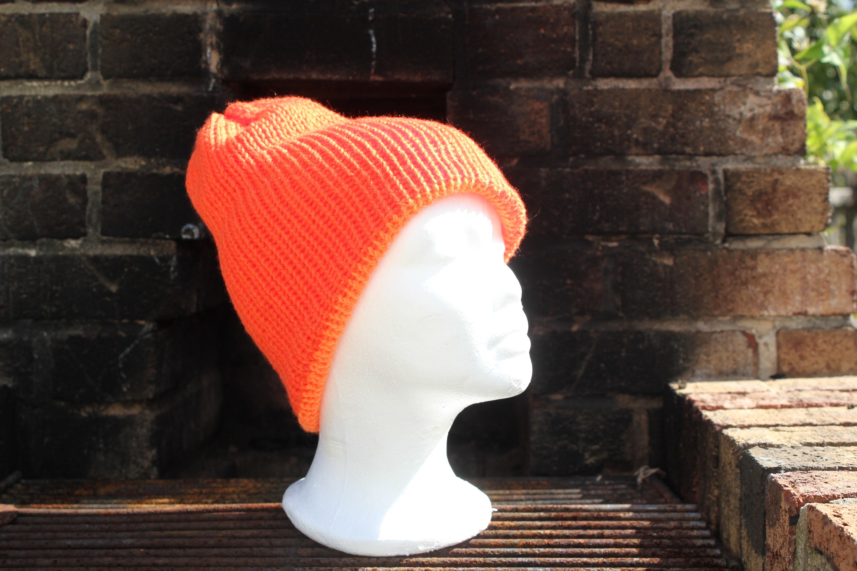 Double orange hat with a pom-pom; excellent for hunting and outdoors warm and dense almost neon orange protects against wind and water