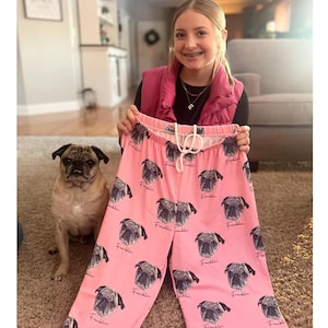May include: Pink sweatpants with a repeated pattern of a pug's face and the name "Franklin" printed on them.