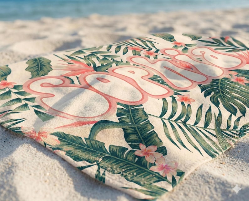 May include: A rectangular beach towel featuring a cream-colored background with a tropical pattern of green palm leaves and pink hibiscus flowers. The name Sophia is printed across the center in large, stylized, bubble-style pink lettering.