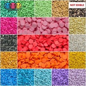 May include: Assortment of 12 colors of small round confetti, not edible. Colors include green, pink, red, orange, blue, purple, yellow, white, black, brown, and gold.