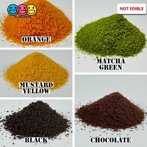 May include: Four piles of colorful sand-like material labeled "Orange", "Mustard Yellow", "Matcha Green", and "Chocolate". The label "Not Edible" is in the top right corner.