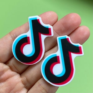 May include: Two white, black, red, and blue TikTok logo stickers. The logos are in a gradient style.