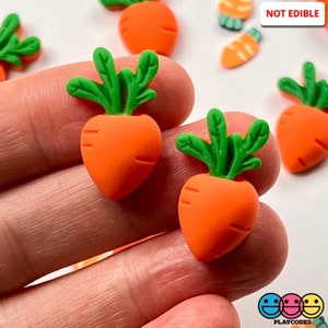 May include: Two orange and green carrot shaped charms with a textured surface.  The charms are made of polymer clay and are not edible.  NOT EDIBLE.