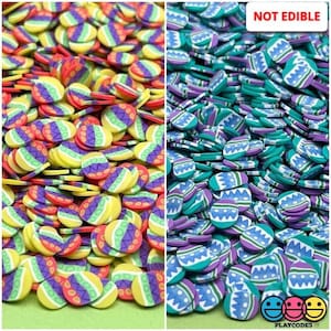 May include: A large pile of colorful Easter egg-shaped sprinkles. The sprinkles are in two colors: yellow, red, and purple, and blue, purple, and teal. The text "NOT EDIBLE" is printed in white on a black background at the top of the image.