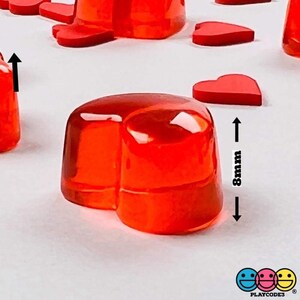 May include: A set of red heart-shaped jelly candies. The candies are about 8mm tall and are arranged on a white surface.