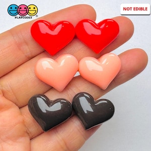 May include: Six heart-shaped resin embellishments in three colors: red, peach, and brown.  The hearts are glossy and have a slight 3D effect.  NOT EDIBLE.