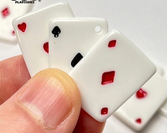 May include: Four white playing cards with red suit symbols. The cards are diamonds, hearts, and spades. The cards are arranged in a stack with the diamond card on top.