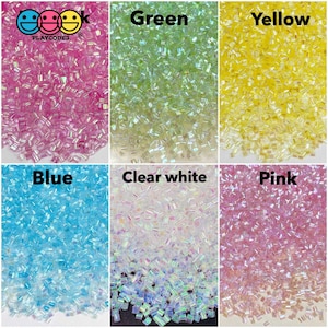 May include: Six containers of iridescent glitter, each with a different color: pink, green, yellow, blue, clear white, and pink. The containers are labeled with the color of the glitter.