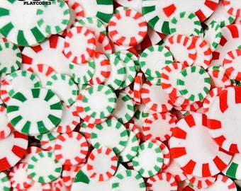 May include: A close-up image of a large pile of red and green peppermint candy-shaped embellishments. The embellishments are made of polymer clay and are not edible.  NOT EDIBLE is printed on the image.