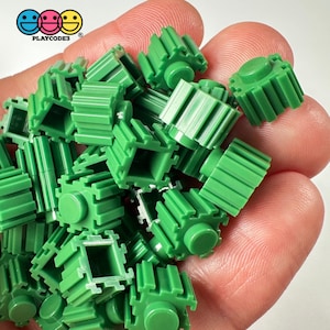 May include: A pile of bright green plastic building blocks with a variety of shapes and textures. The blocks are designed to connect together to create structures.