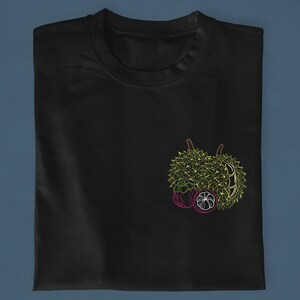 May include: Black t-shirt with a green durian and purple mangosteen fruit design.