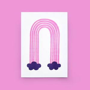 Peut inclure: Un arc-en-ciel rose et blanc avec des nuages violets sur un fond blanc. L'arc-en-ciel est composé de rayures verticales et les nuages sont des formes simples.