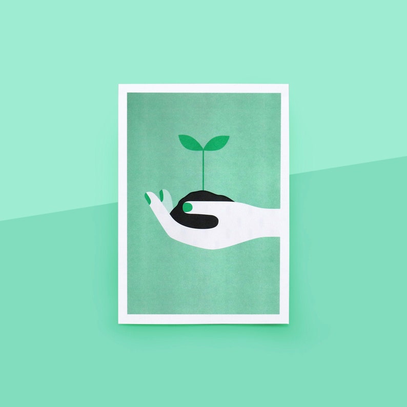 Op de afbeelding: Een witte hand met groene nagellak houdt een kleine groene plant vast met twee bladeren die uit een zwarte aardehoop groeien.