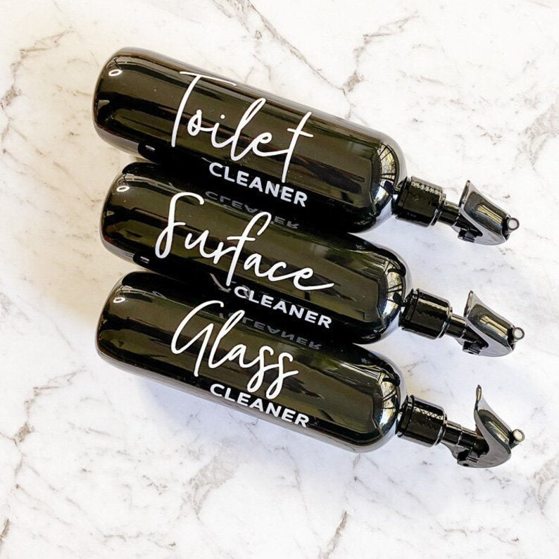 May include: Three black spray bottles with white labels. The labels read "Toilet Cleaner", "Surface Cleaner", and "Glass Cleaner".