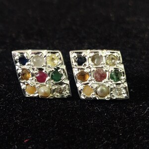 May include: A pair of rhomboid-shaped earrings crafted from silver-toned metal, each featuring a grid of nine small, multi-colored gemstones including blue, yellow, red, green, and white stones set in a textured, metallic frame.