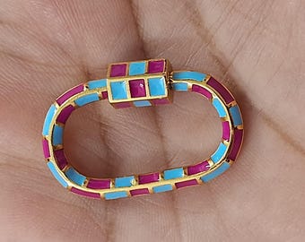 May include: A gold-toned clasp with a rectangular center and an oval body. The clasp is decorated with alternating squares of turquoise and magenta enamel. The clasp is a jewelry component.