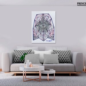 May include: A geometric abstract art print with a white background and a blue and pink geometric design. The print is framed and hanging on a wall in a living room setting.
