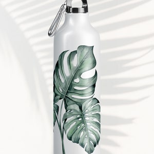 May include: White reusable water bottle with a silver lid and a carabiner clip. The bottle has a green and white tropical leaf design.