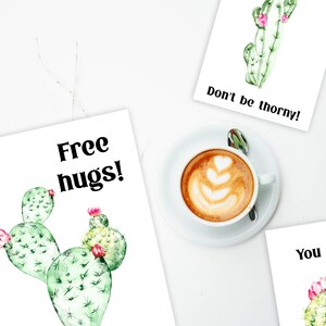 May include: Three printable cards with watercolor cactus illustrations and text. The first card says "Free hugs!" and features a green cactus with pink flowers. The second card says "Don't be thorny!" and features a green cactus with pink flowers. The third card says "You and me" and features two green cacti with pink flowers.