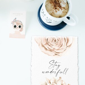 May include: A watercolor print with a beige background and two beige roses. The text "Stay wonderful" is written in black cursive script.