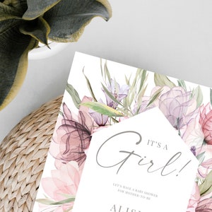 May include: A baby shower invitation with a watercolor floral design in shades of pink and purple. The text reads "It's a Girl!" and includes the name "Alisia", the date "May 25th, 2021", the time "4 pm", the location "Sanctuary Park, 670 Royal Street, Brydan, Amsterdam", and the phrase "Reception to follow".
