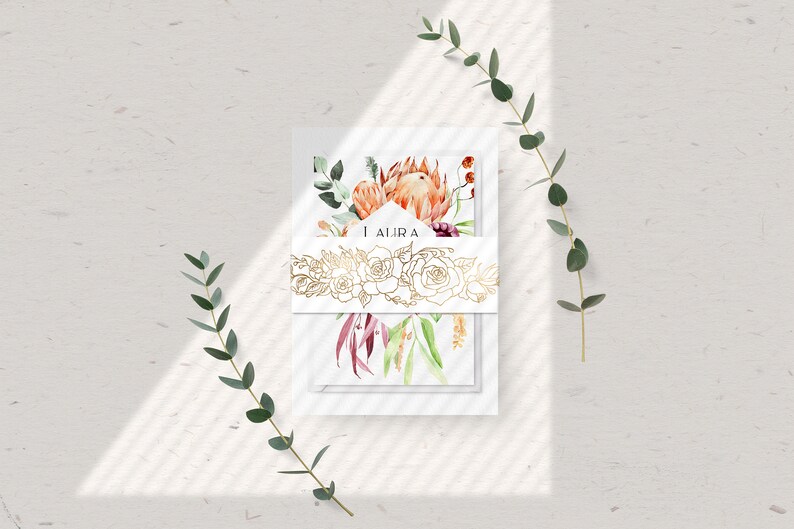 May include: A set of white cards with a watercolor floral design featuring proteas, eucalyptus, and other flowers. The cards are tied together with a gold ribbon with a floral design and the word "AJIRA" printed on the ribbon.