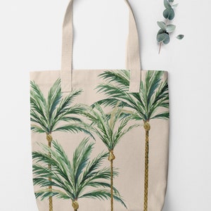 May include: A beige canvas tote bag with a design of four green palm trees on a beige background.