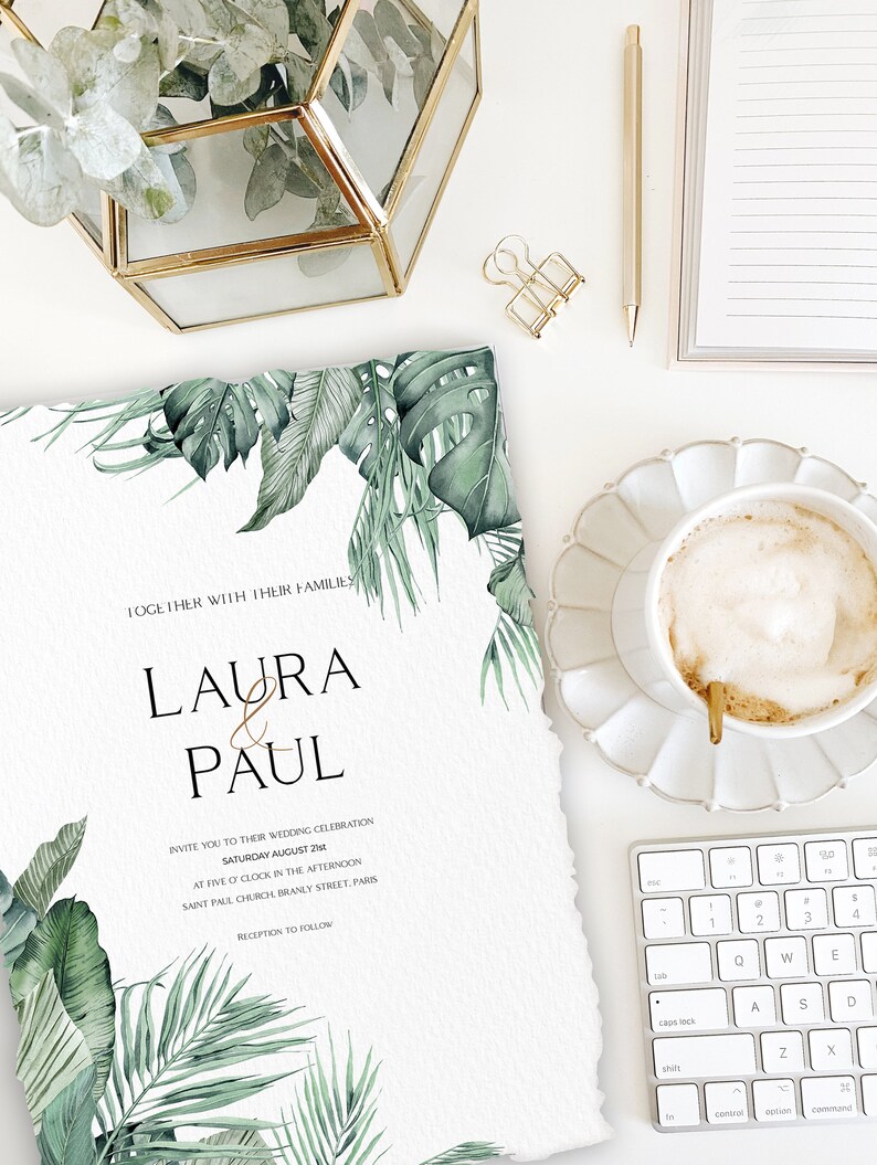 May include: Wedding invitation with tropical leaves and the text "Laura & Paul" in gold lettering. The invitation details the wedding date, time, and location: Saturday, August 2nd at five o'clock in the afternoon at Saint Paul Church, Branly Street, Paris. Reception to follow.