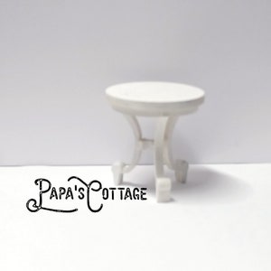 May include: White miniature table with a round top and four legs. The table is made of wood and has a simple design.
