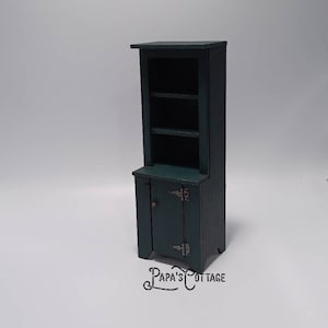 May include: A dark green wooden hutch with two shelves and a cabinet with two doors. The cabinet has two metal hinges on each door. The hutch is on a white background.