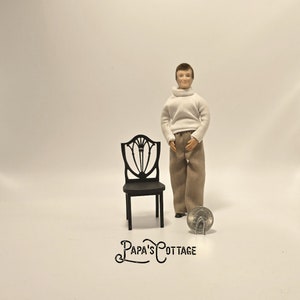 May include: A black wooden dollhouse chair with a carved back and a simple design. The chair is about the size of a quarter.