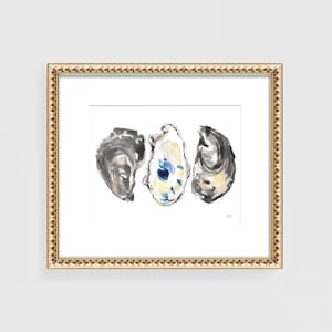 May include: A watercolor painting of three oyster shells. The shells are painted in shades of gray, white, and blue. The painting is framed in a gold frame.