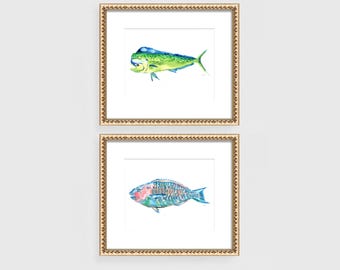 Peut inclure: Deux impressions encadrées à l'aquarelle de poissons. L'impression supérieure présente un mahi-mahi vert et jaune. L'impression inférieure montre un poisson perroquet coloré. Les deux impressions sont dans des cadres dorés ornés, parfaits pour la décoration côtière.