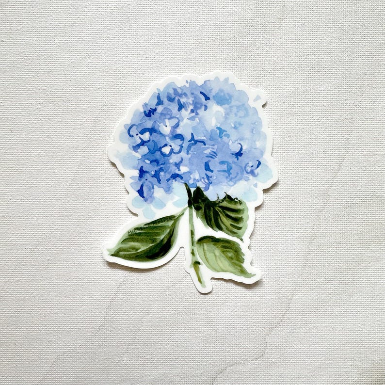 May include: A sticker featuring a watercolor illustration of a blue hydrangea flower. The flower has multiple shades of blue and green leaves. The sticker is on a white background.