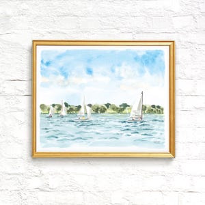 May include: Watercolor painting of sailboats on a lake under a blue sky. The artwork features several white sailboats with their sails up, sailing on a light blue body of water. Green trees line the horizon, and the painting is framed in a gold frame.