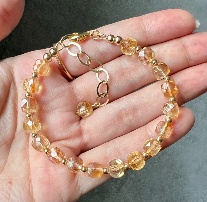 May include: A gold bracelet with a chain clasp and faceted citrine beads.