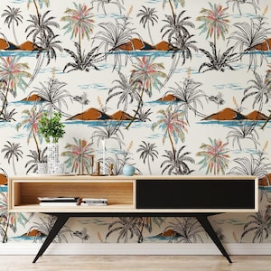 May include: A contemporary console table in light wood and black, with a distinctive black leg design. The backdrop showcases a tropical wallpaper featuring palm trees, mountains, and water in a repeating pattern. Decorative vases and candles adorn the table.