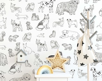 May include: A white wall covered in black and white dog illustrations. A wooden star-shaped light, a rainbow-shaped toy, and a small white nightstand are in the foreground. A coat rack with a star-patterned bag hangs on the right.