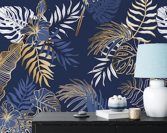 May include: A dark navy blue wallpaper featuring a repeating pattern of tropical palm leaves and hibiscus flowers in shades of white, gold, and blue. A white table lamp with a light blue shade sits on a black surface in front of the wallpaper.