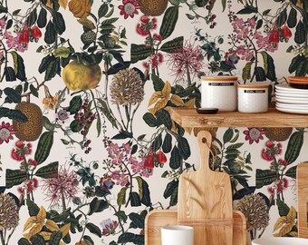 Op de afbeelding: Behang met een botanisch patroon van diverse vruchten, bloemen en groene bladeren op een crèmekleurige achtergrond. Het ontwerp bevat illustraties van jackfruit, citrusvruchten en roze bloesems. Het behang is zichtbaar achter houten keukengerei.
