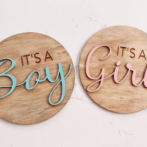 Gender Reveal Zeichen. Es ist ein Junge. Es ist ein Mädchen. Krankenhaus-Fotoanzeige. 3D Schild aus Holz zur Geburtsanzeige.