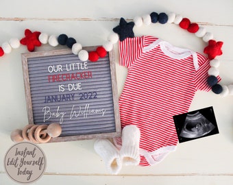 Op de afbeelding: Een letterbord met de tekst "Our little firecracker is due January 2022 Baby Williams" in rode, witte en blauwe letters. Een rood-wit gestreept rompertje, een paar witte slofjes, een houten rammelaar en een echobeeld zijn rond het letterbord gerangschikt.