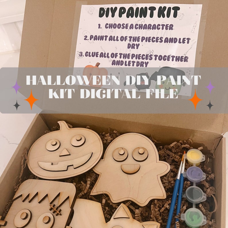 May include: A Halloween DIY paint kit featuring wooden cutouts of a pumpkin, ghost, Frankenstein, and a cat. The kit includes paint pots in yellow, blue, green, and purple. The kit is in a brown cardboard box with shredded paper.