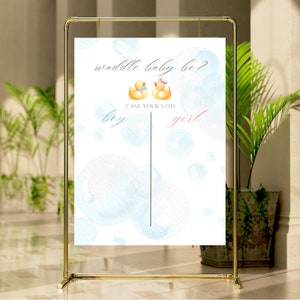 May include: A gender reveal party sign with a white background and blue and pink watercolour bubbles. The sign says "Waddle baby be?" with two yellow rubber duckies, one with a blue bow tie and one with a pink bow. The sign also says "Cast your vote" with "boy" and "girl" written below the ducks.