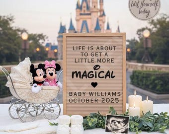May include: A wooden letter board with the text "Life is about to get a little more magical" and "Baby Williams October 2025". The letter board is sitting on a table with a white blanket, two Mickey Mouse plush toys, a baby carriage, two white booties, a candle, and a framed ultrasound image.