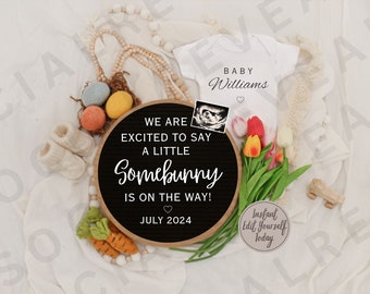 Könnte beinhalten: Ein schwarzes Schild aus Schiefer mit dem Text "We are excited to say a little Somebunny is on the way!" und "July 2024". Ein weißer Strampler mit dem Text "Baby Williams" ist im Hintergrund. Das Schild ist von verschiedenen Osterdekorationen umgeben, darunter Karotten, Eier und Blumen.