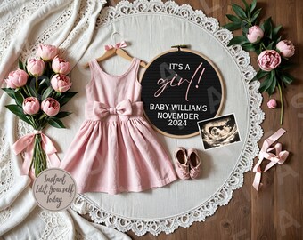 Op de afbeelding: Een roze babyjurk met een strik, een paar roze babyschoentjes, een zwart letterbord met de tekst "It's a girl! Baby Williams November 2024", een roze bloemenboeket en een roze lint op een witte kant achtergrond.